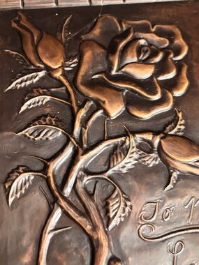 Vintage embossed copper wall plaque features a prominent rose motif